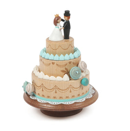 wooden music box of wedding cake with a couple at the top